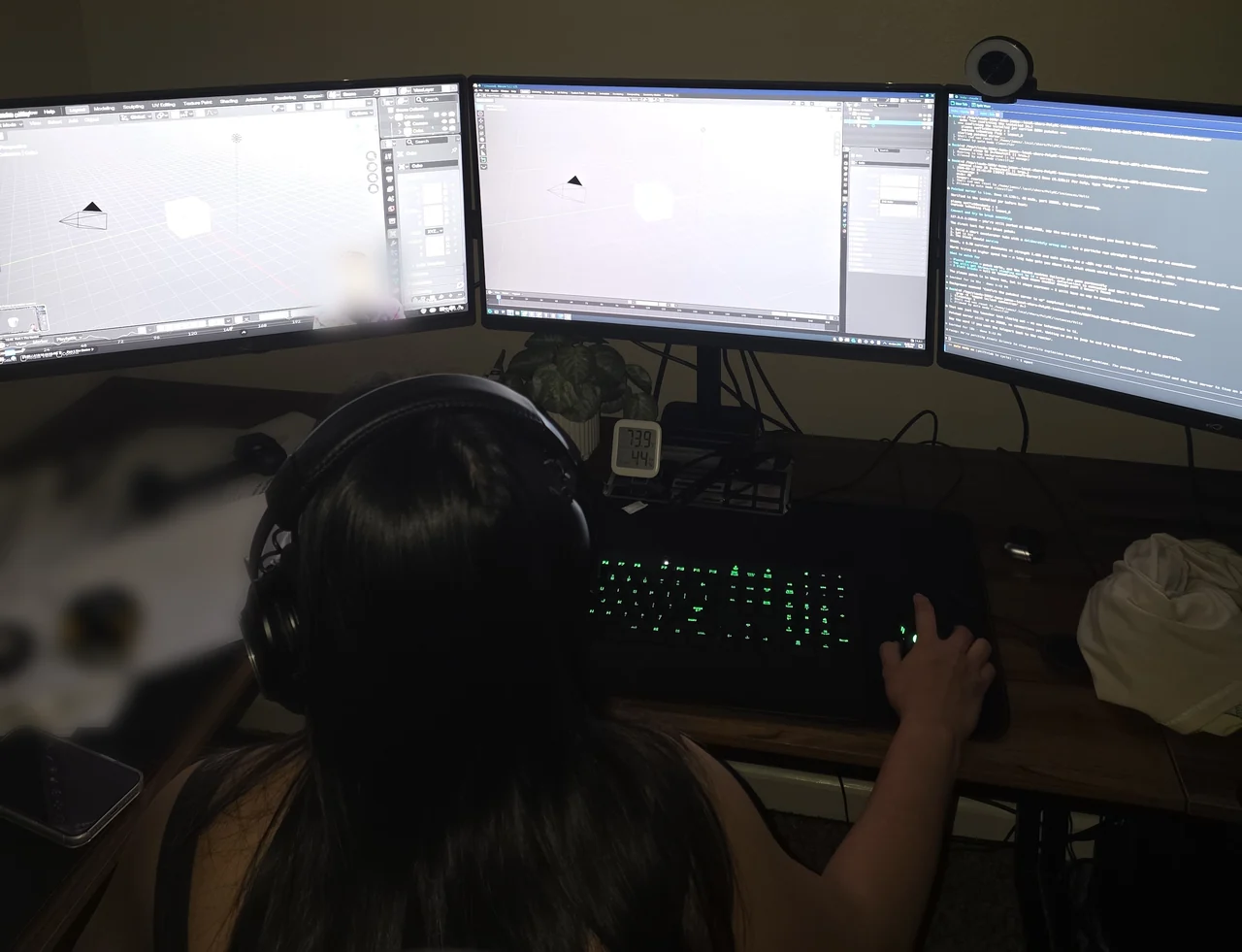 Ging at the desk, learning Blender across three monitors.
