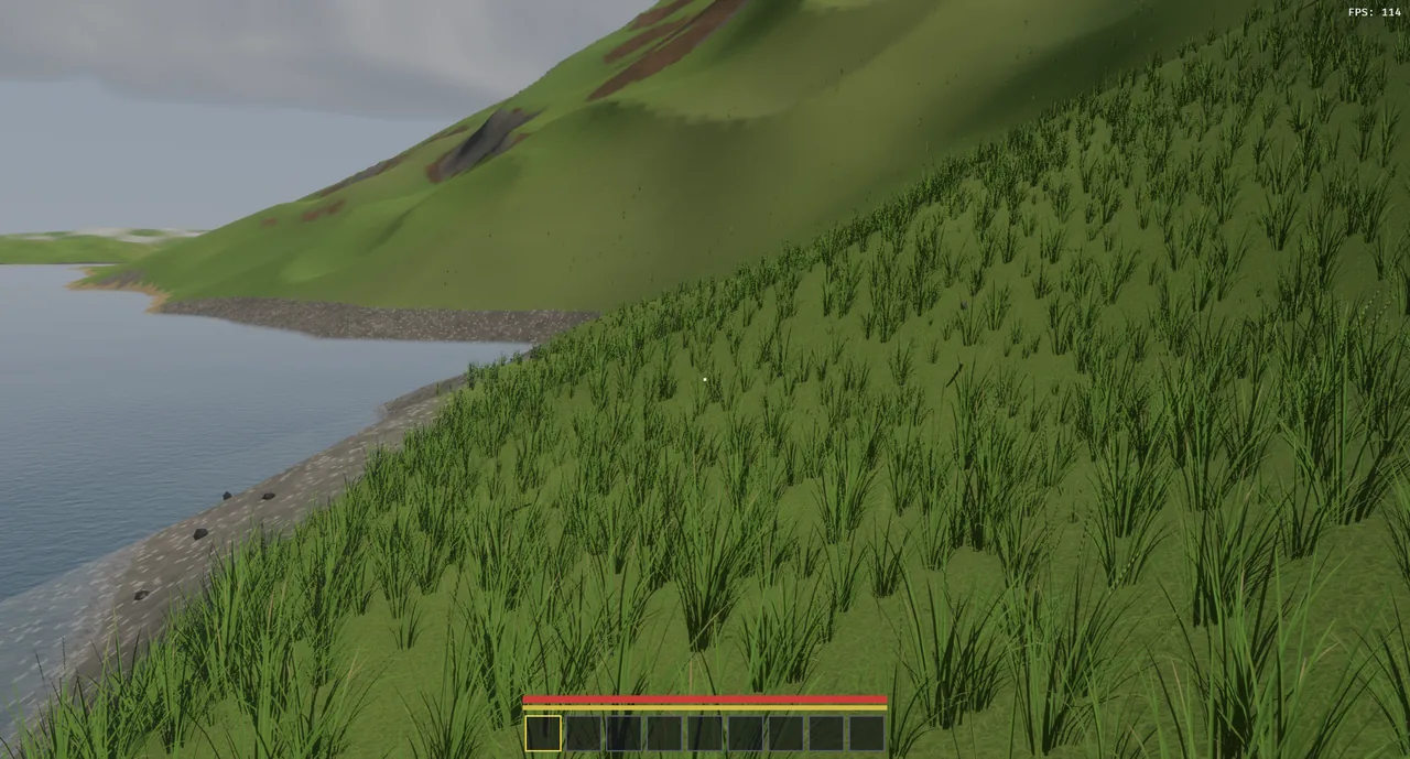 The new water below a grassy hillside, the pebbled bed visible through the shallows along the shore.